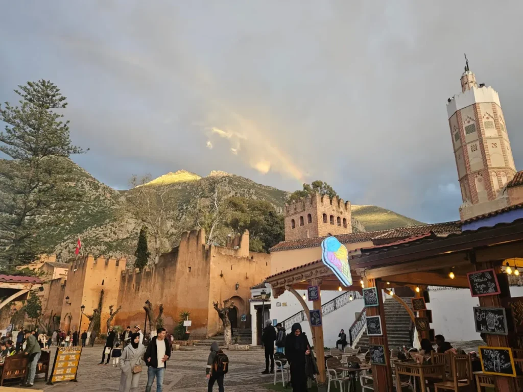 Outa el Hammam square in Chefchaouen, with the kasbah walls and the mosque’s octagonal minaret against the Rif Mountains