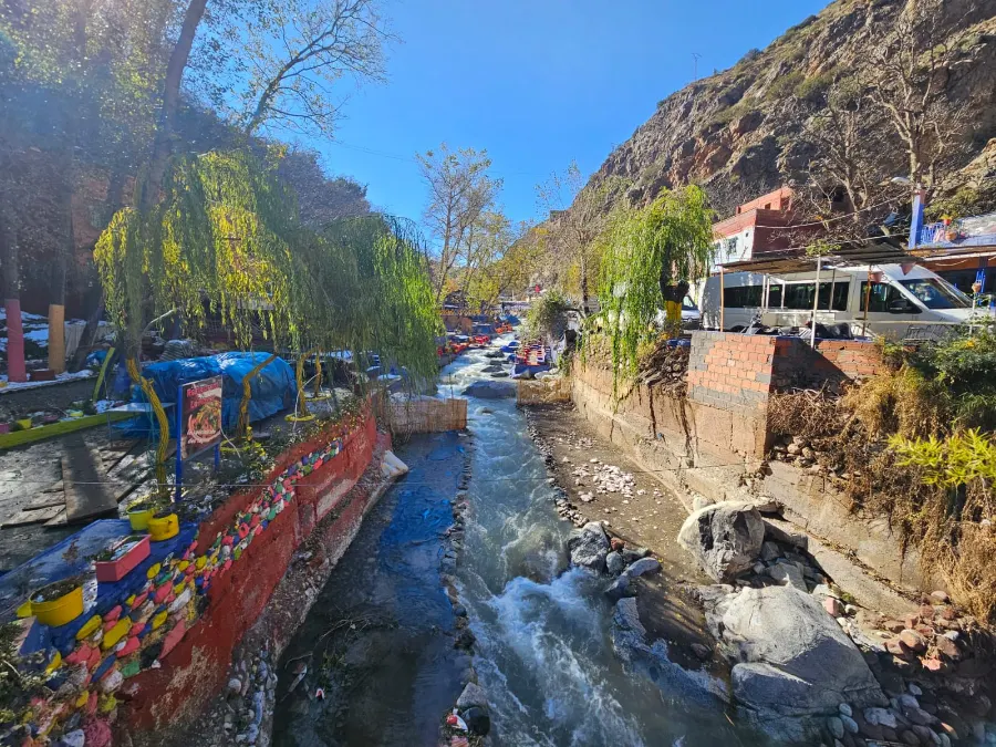 A mountain river running past colorful riverside cafés in a High Atlas valley